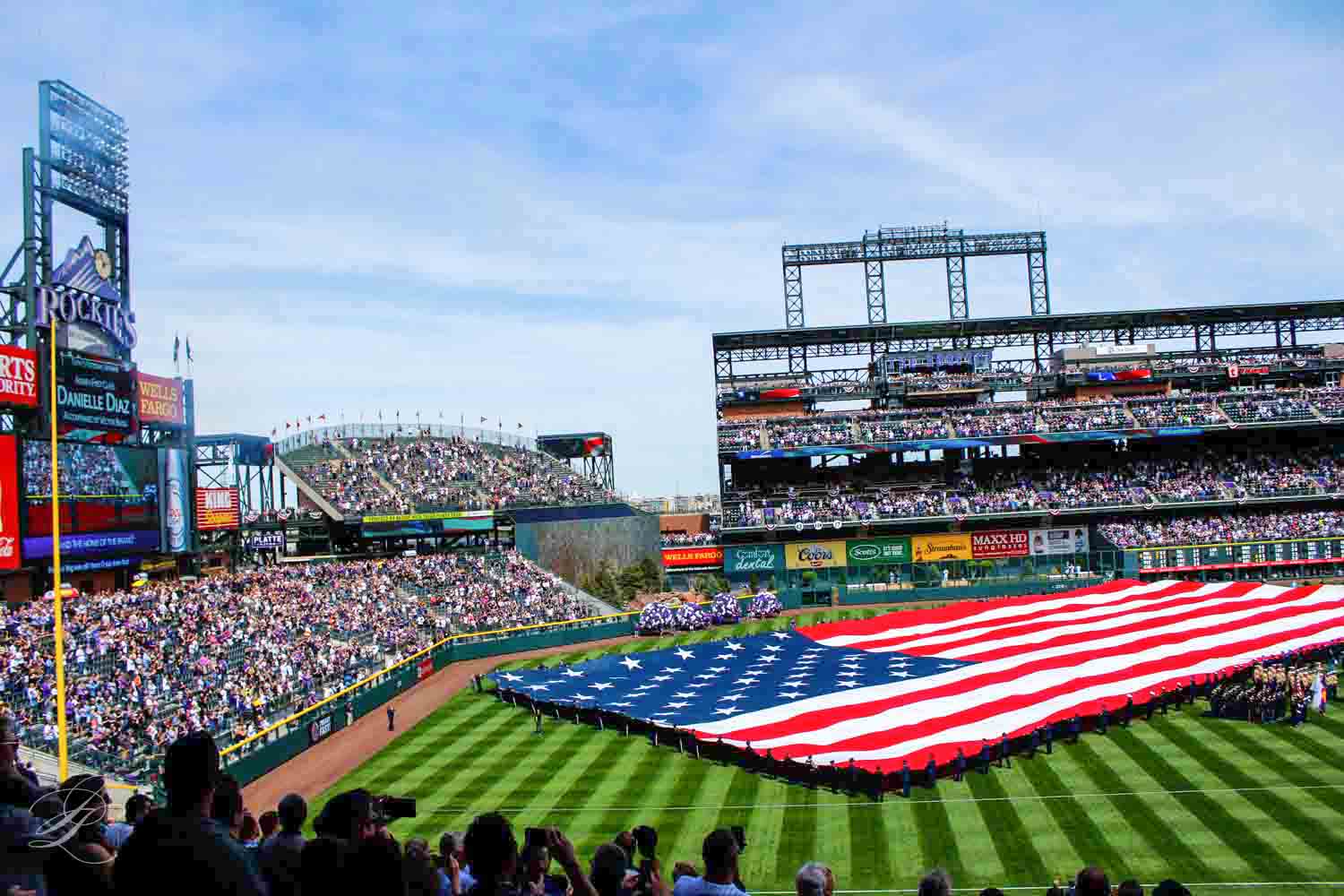 Lapangan bisbol Rockies dengan bendera Amerika pada hari pembukaan