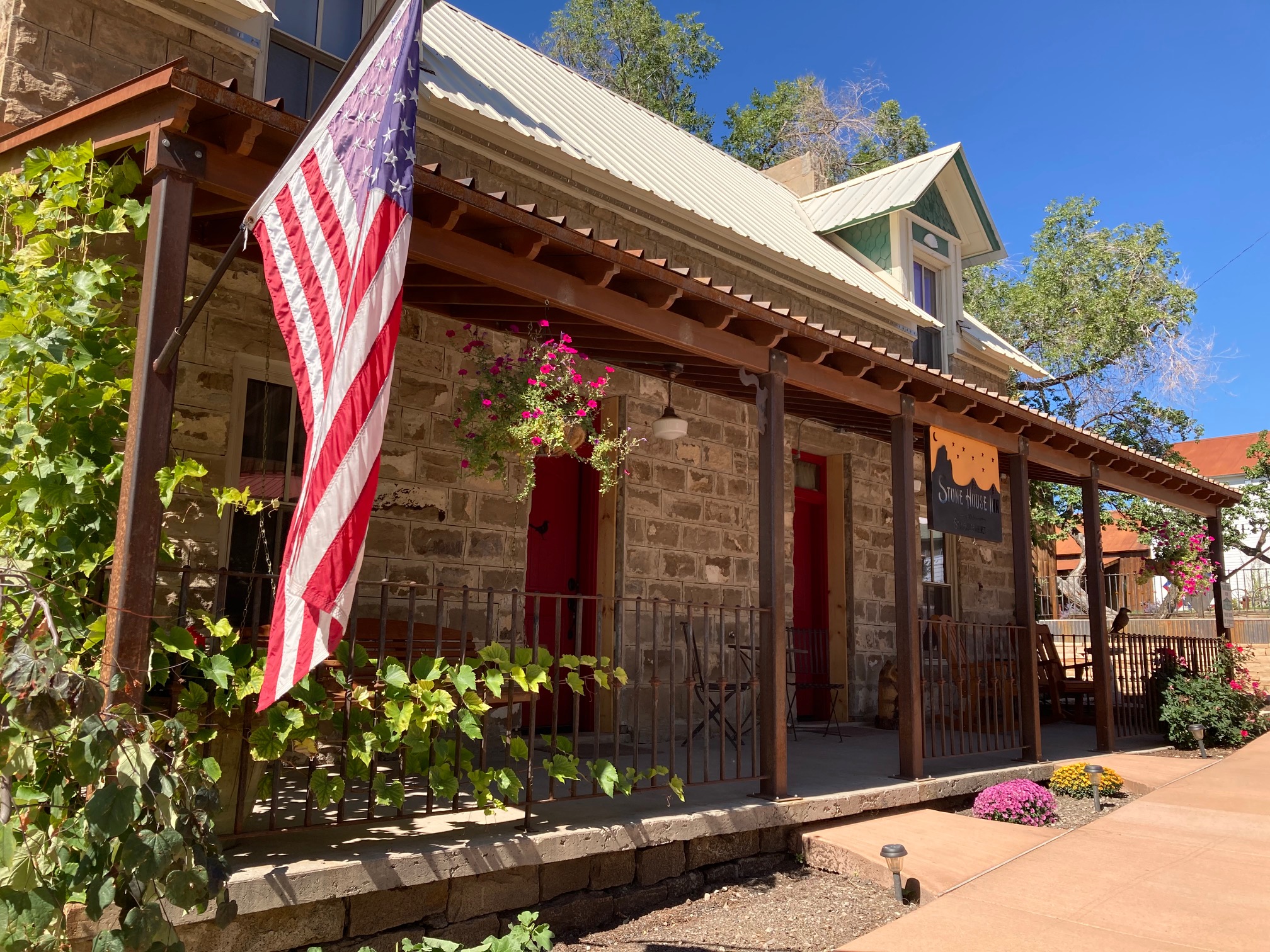 Outside of Stone House Inn with planters and an American flag