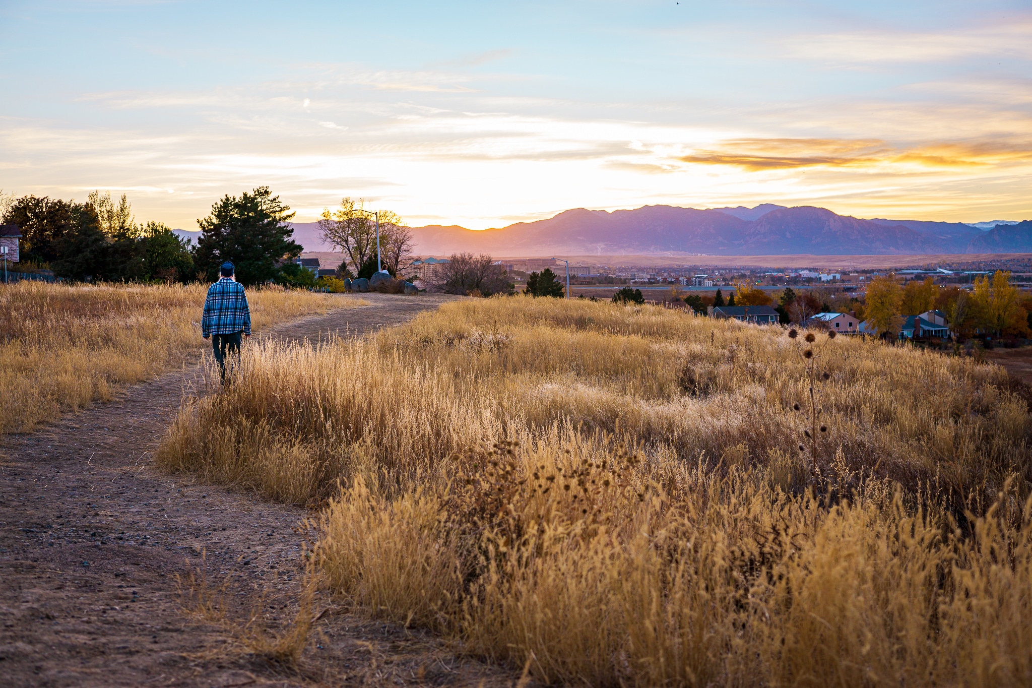 Person walking on trail at sunset