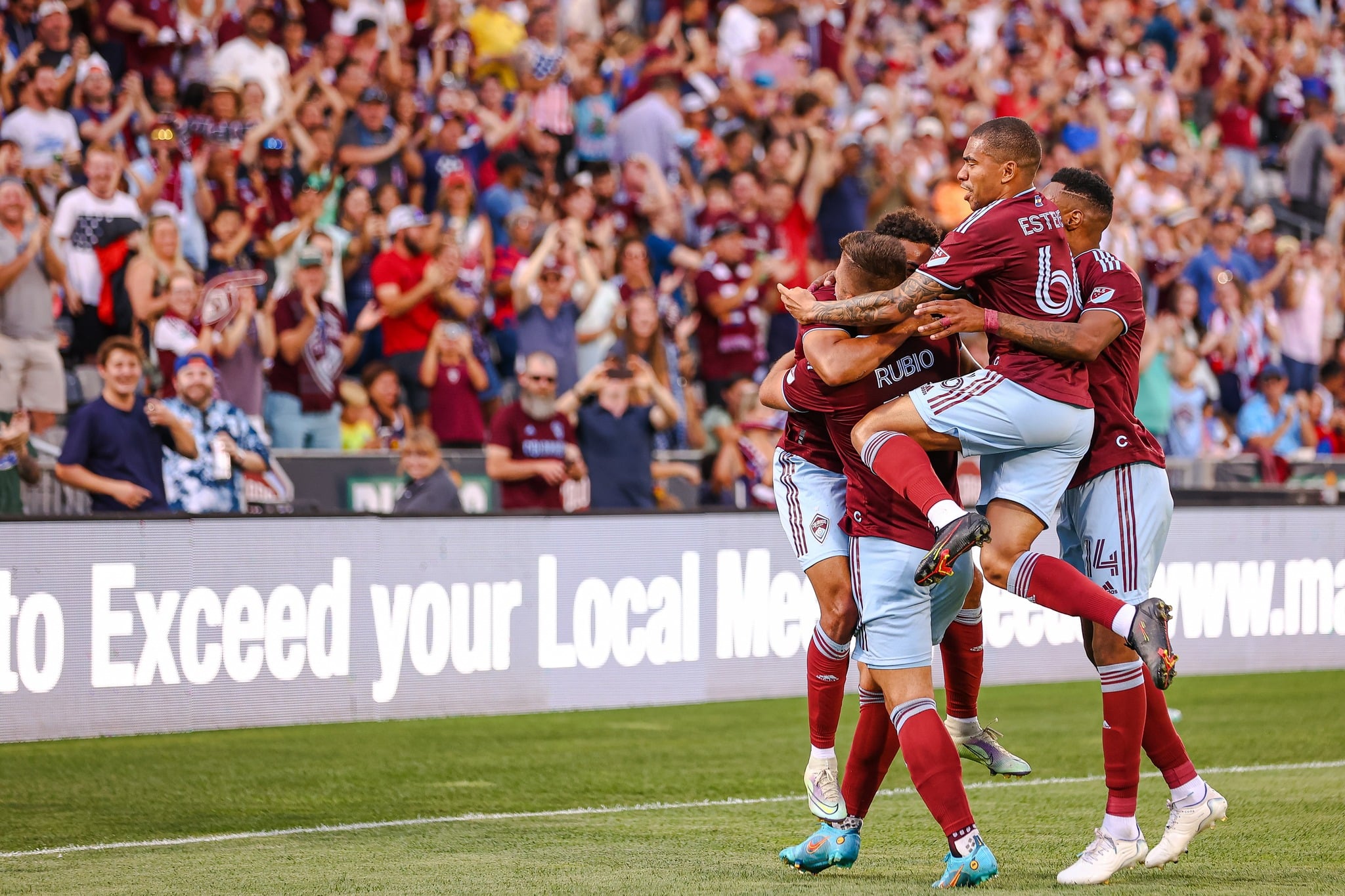 Colorado Rapids soccer plays jumping up into a group hug during a game