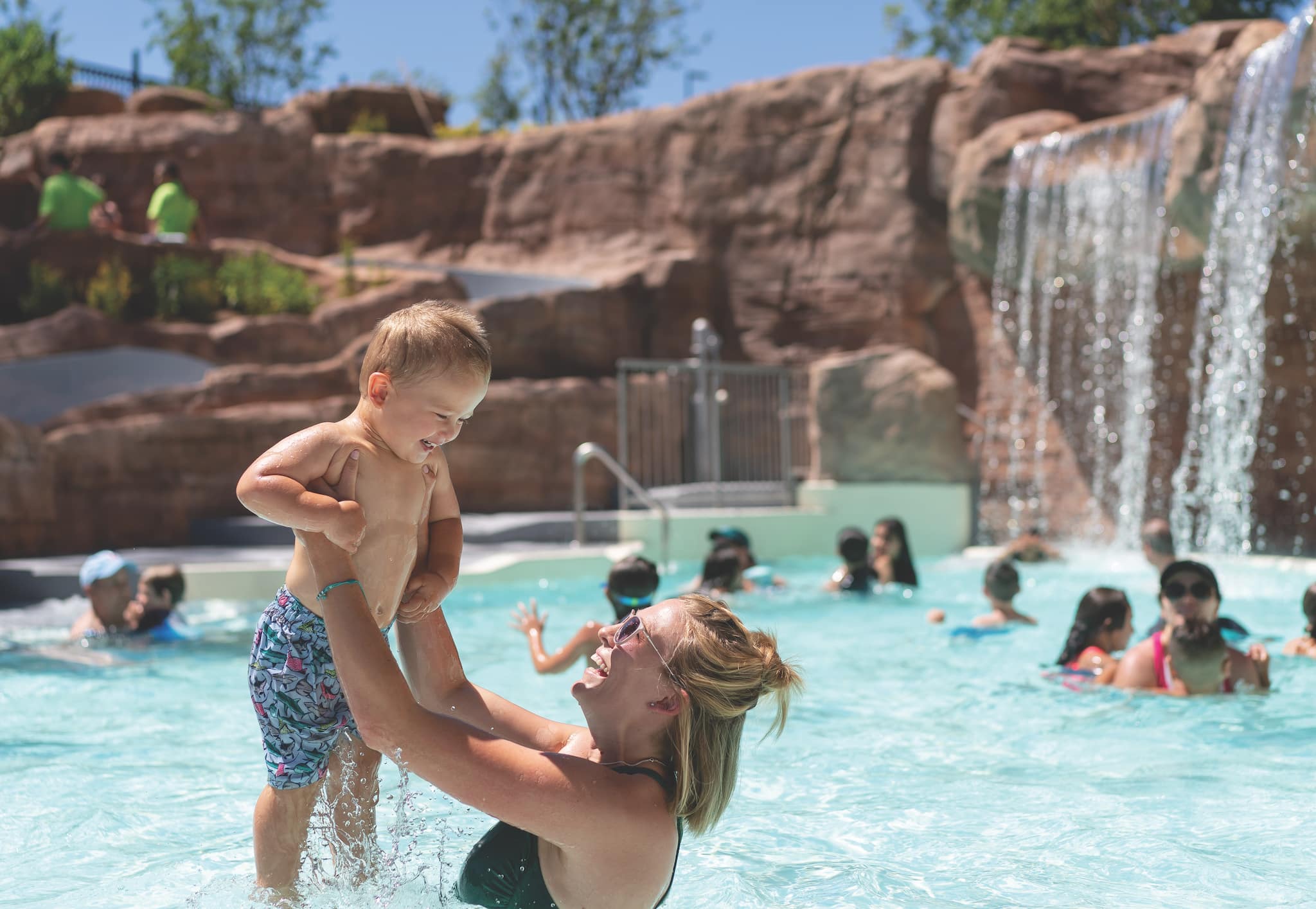 Mom holds baby up out of the water at Glenwood Hot Springs Sopris Splash Zone