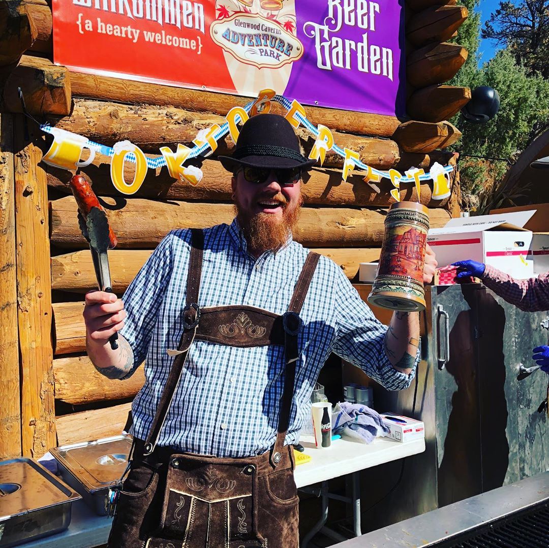 Man in german attire holding a bratwurst