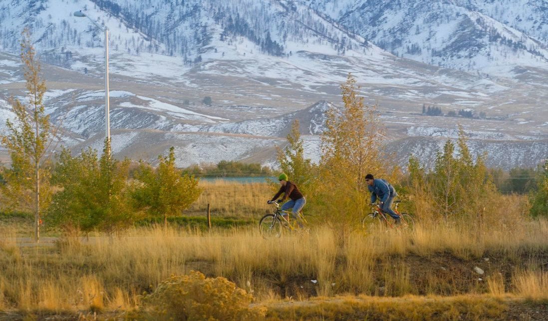 Bikers on trail with mountains in the back