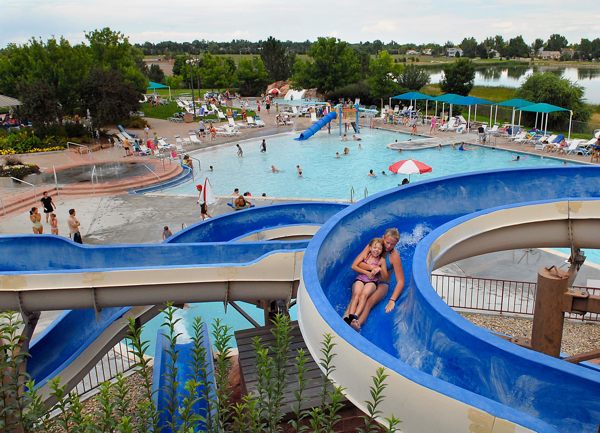 Two kids going down a blue slide at The Bay waterpark