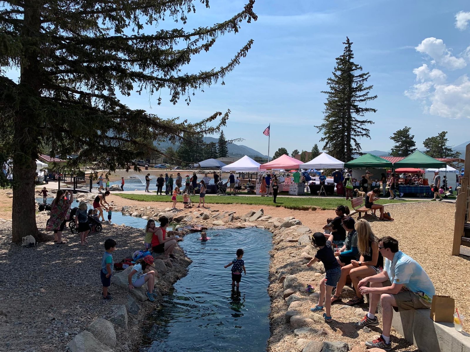 Image of people playing in the stream at the Woodland Park Farmers Market, Colorado