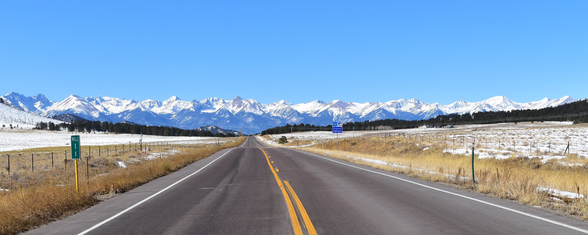 View of snow-covered mountains from highway