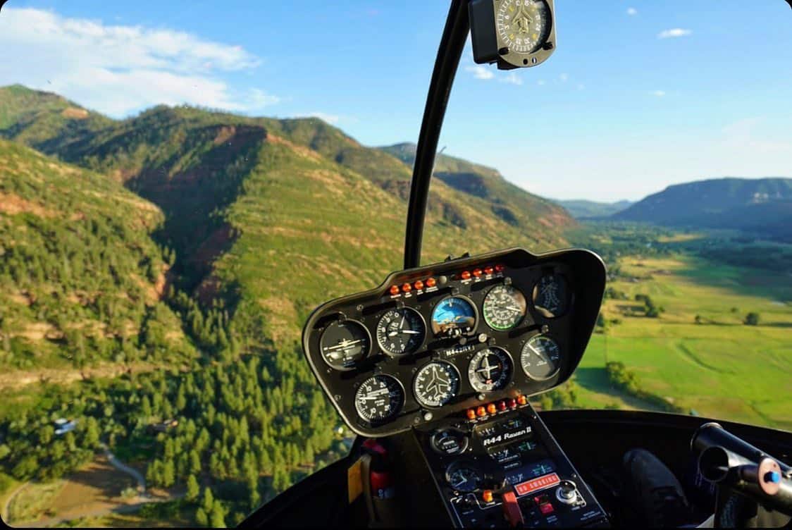 View of a green valley from the front of a helicopter