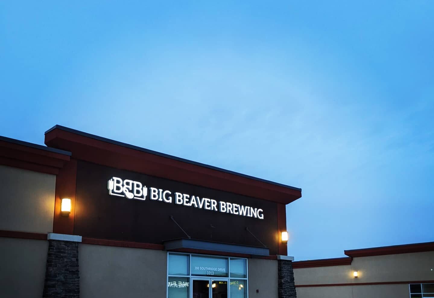 Building with Big Beaver Brewing sign at dusk