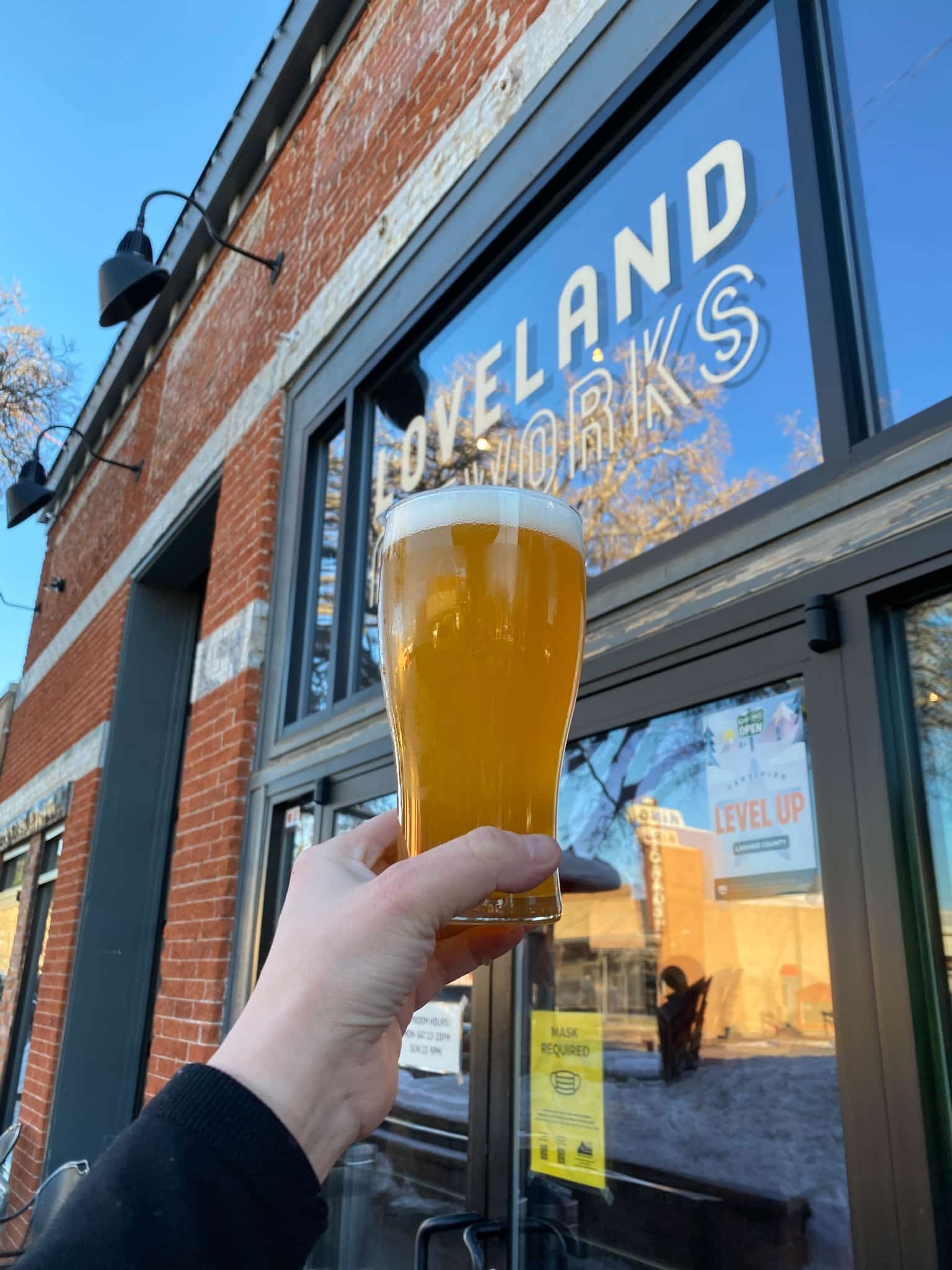 Glass of beer in front of Loveland Aleworks entrance