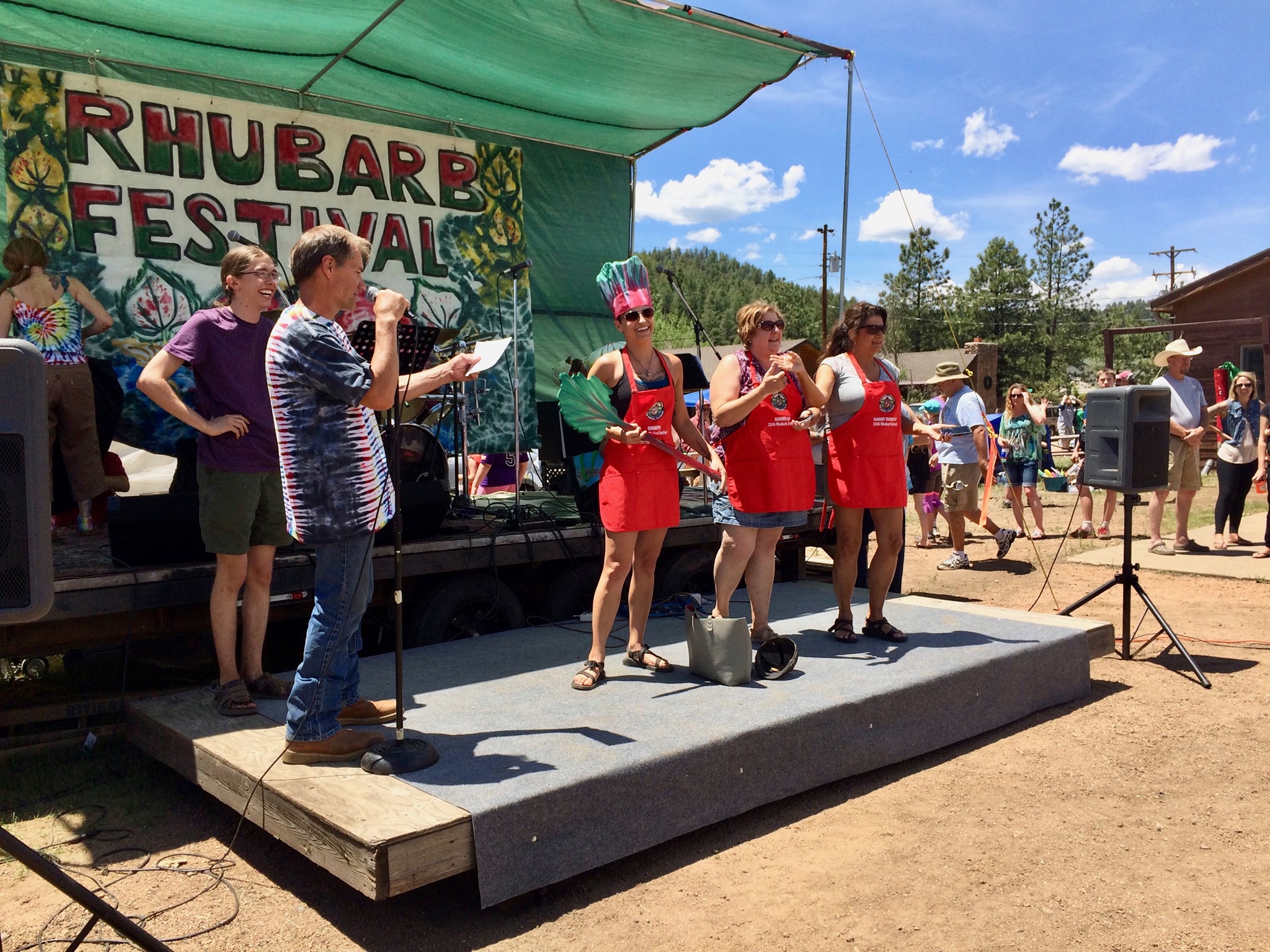 Presenters on stage holding stalks of rhubarb