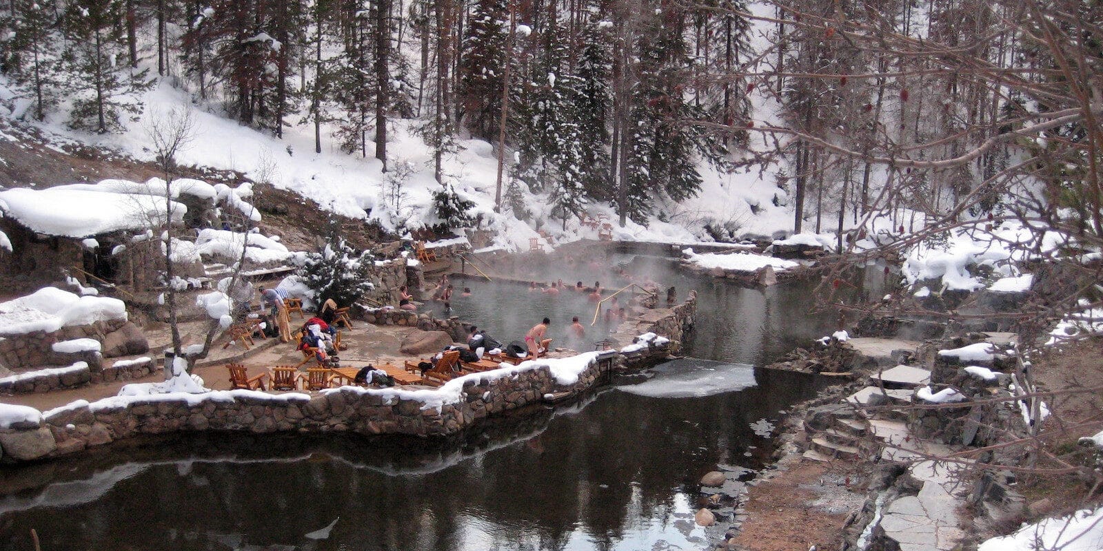 Image of people soaking in the Strawberry Park Hot Springs during winter in Steamboat Springs, Colorado