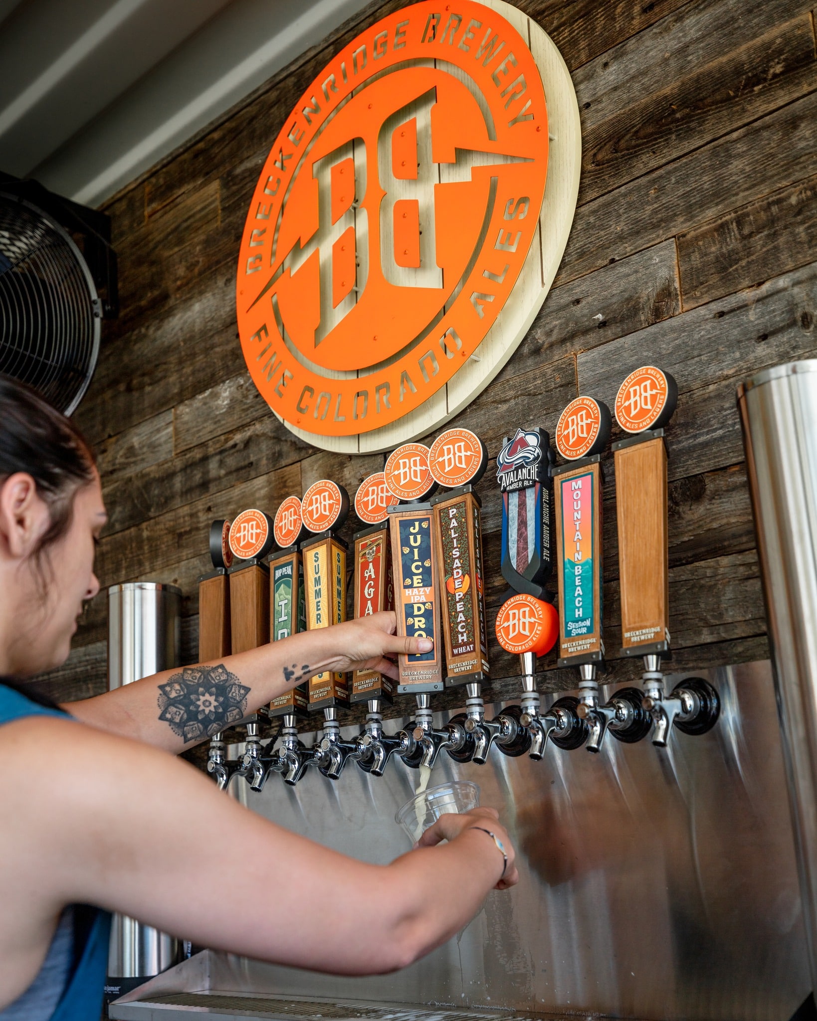 Employee filling a beer glass from tap