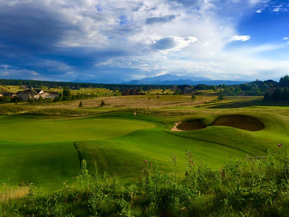 Green golf course with mountains in the back