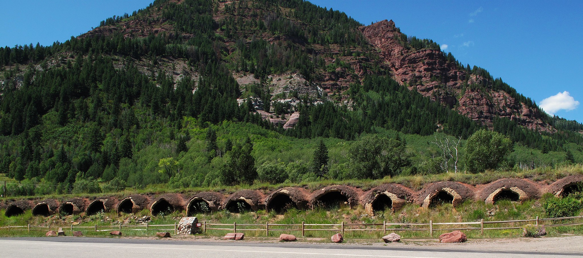 Little brick ovens underneath a grassy hill