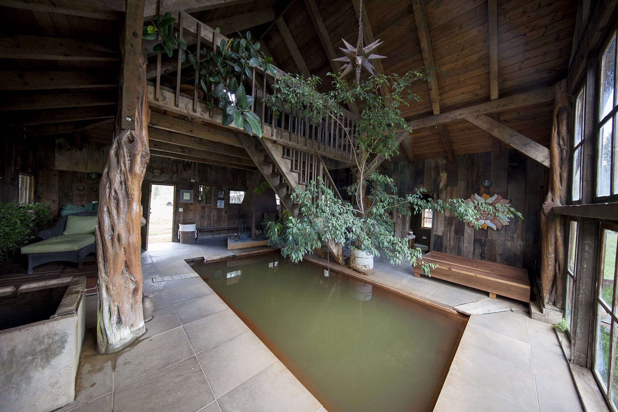 Indoor soaking pool with lots of plants and big windows