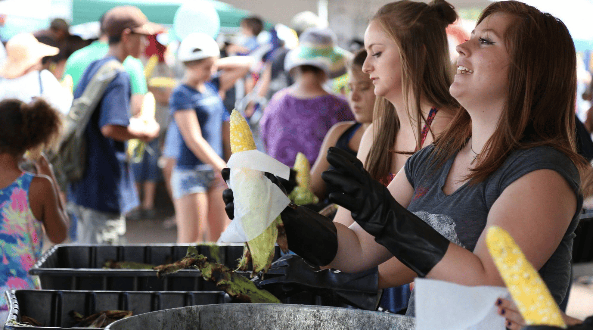 Girl handing corn to a guest 