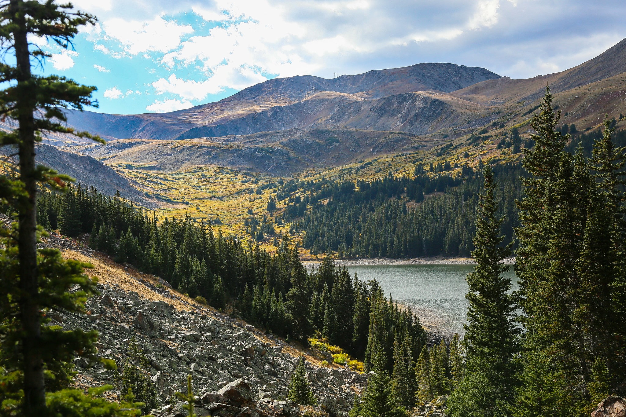 Alpine lake in a valley with golden aspens