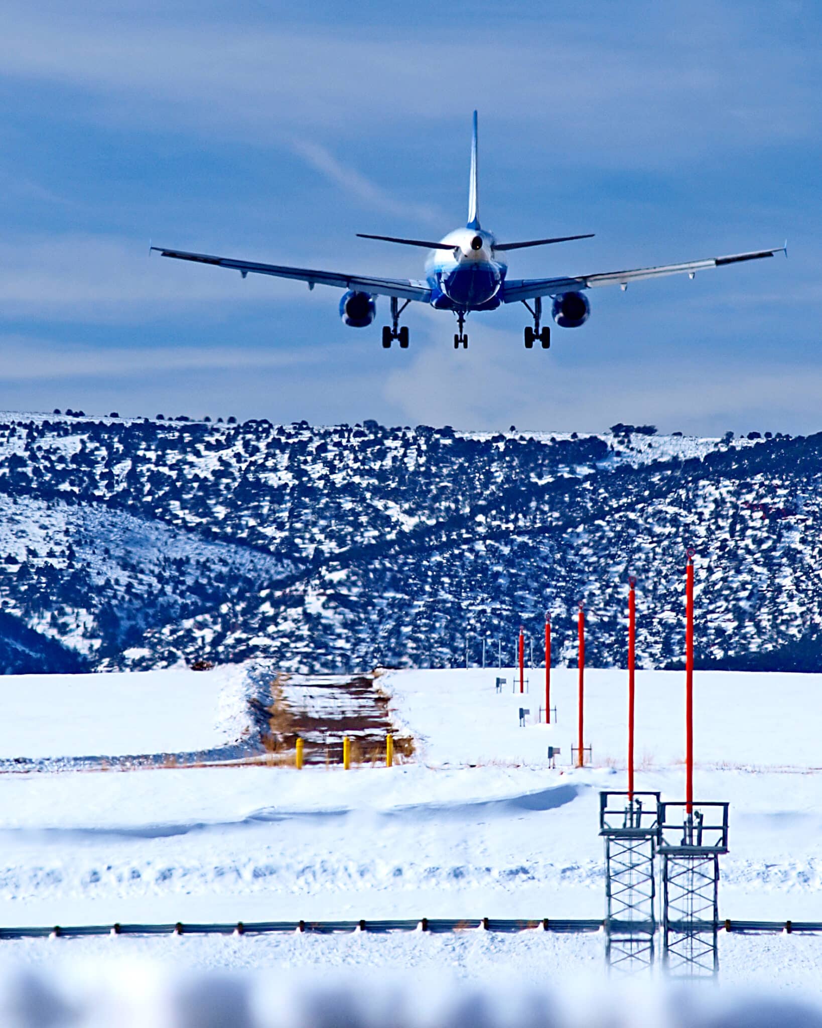 White plane about to touchdown on a snowy runway