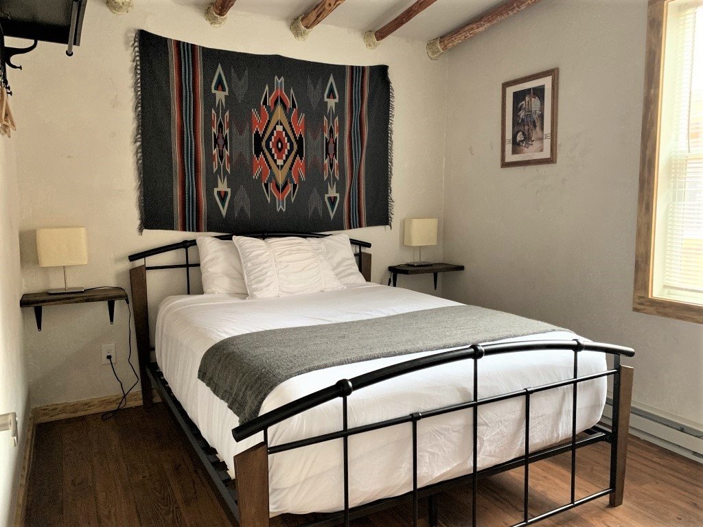 Hotel room with queen bed and native inspired tapestry