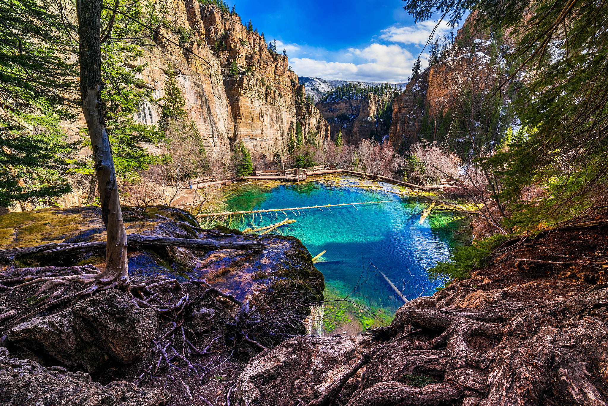 Bright blue lake surrounded by trees and rock walls