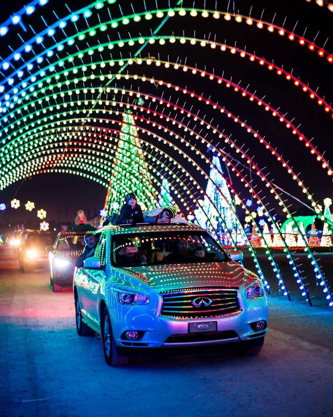 Infiniti SUV driving under a light arch at the Christmas Light drive-thru at Water World