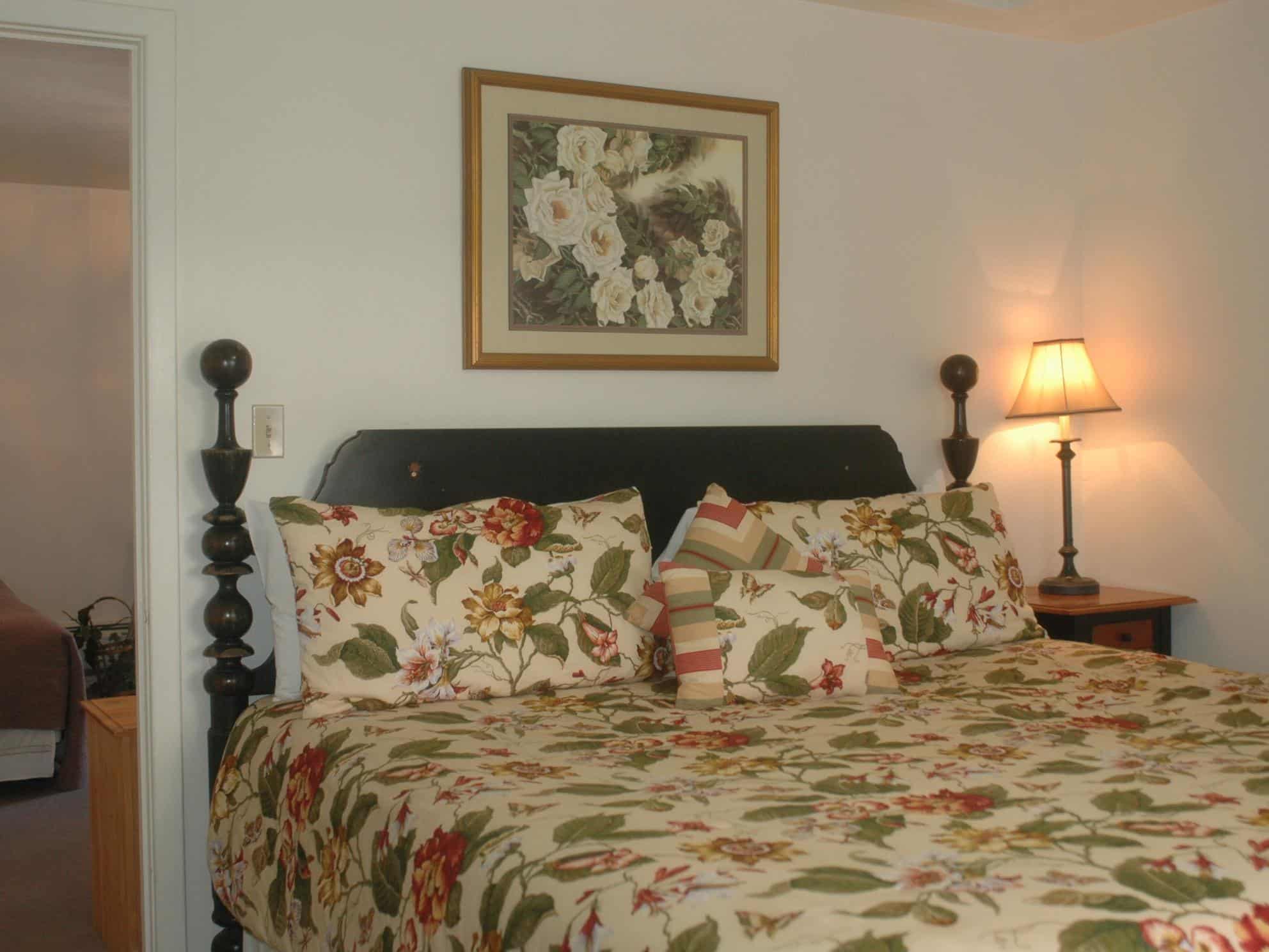 queen bed with a floral blanket