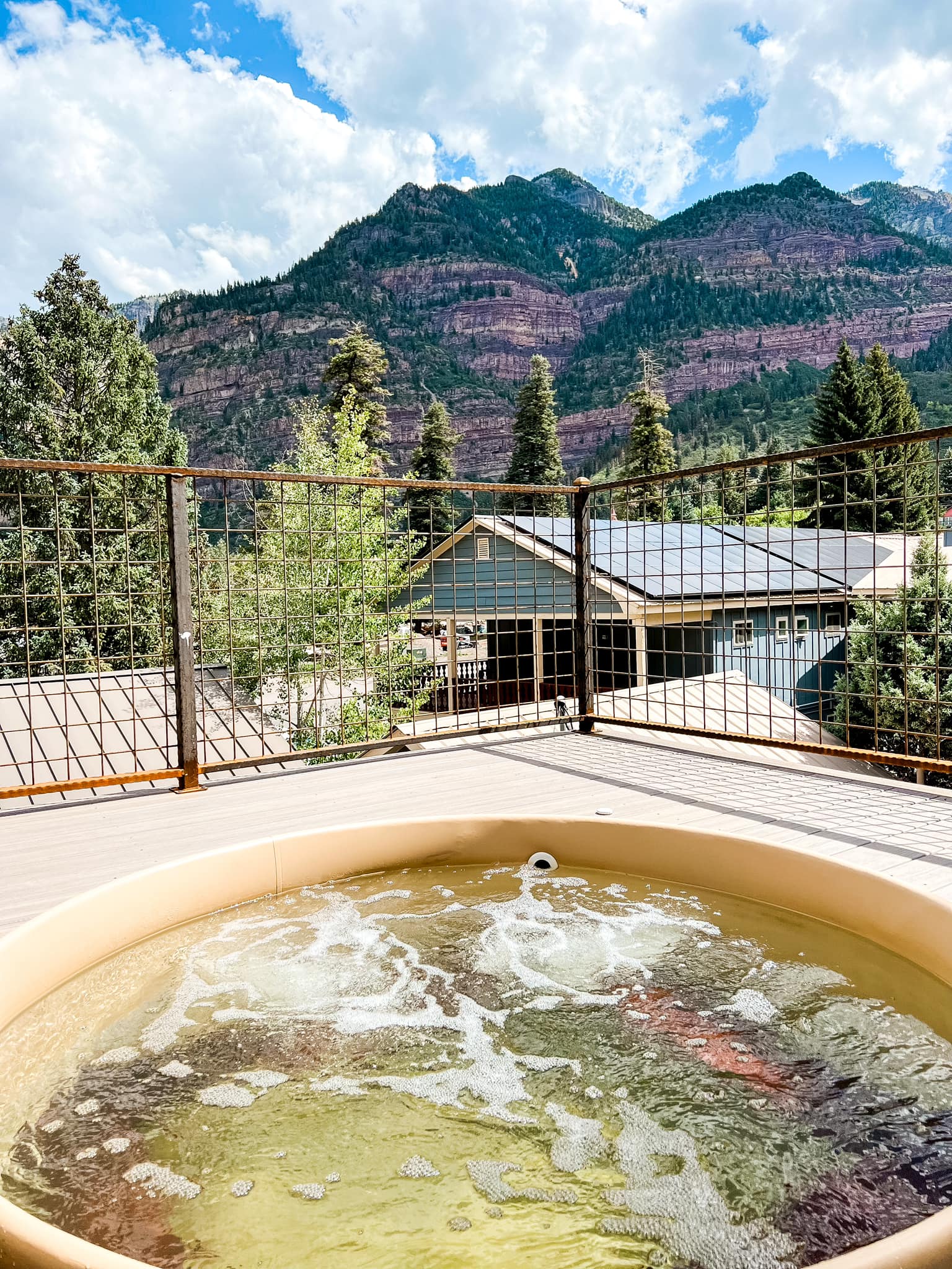 Mineral hot spring tub on deck overlooking mountains