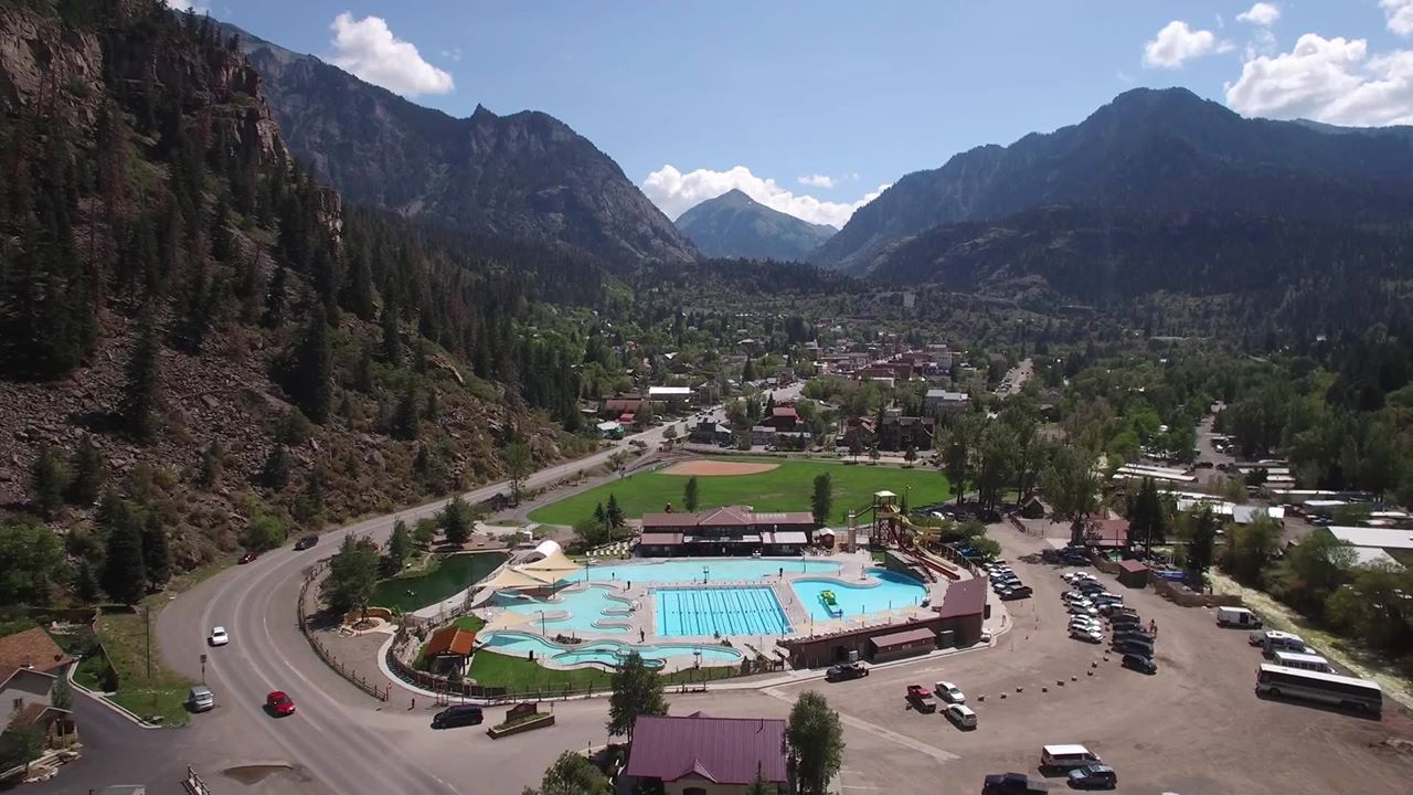 Aerial view of hot springs pool complex in a mountain valley