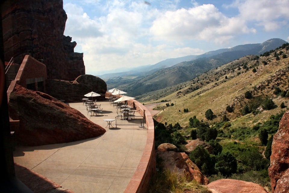 Concrete patio overlooking rolling green hills and a few red rock formations at the Ship Rock Grille at Red Rocks Amphitheatre