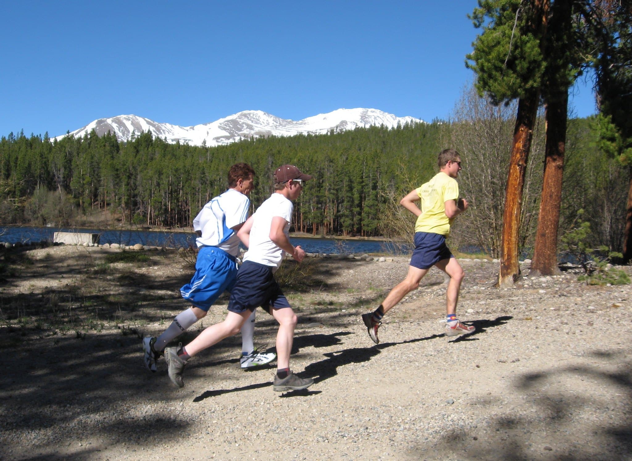 Three runners during a 5k around a small lake