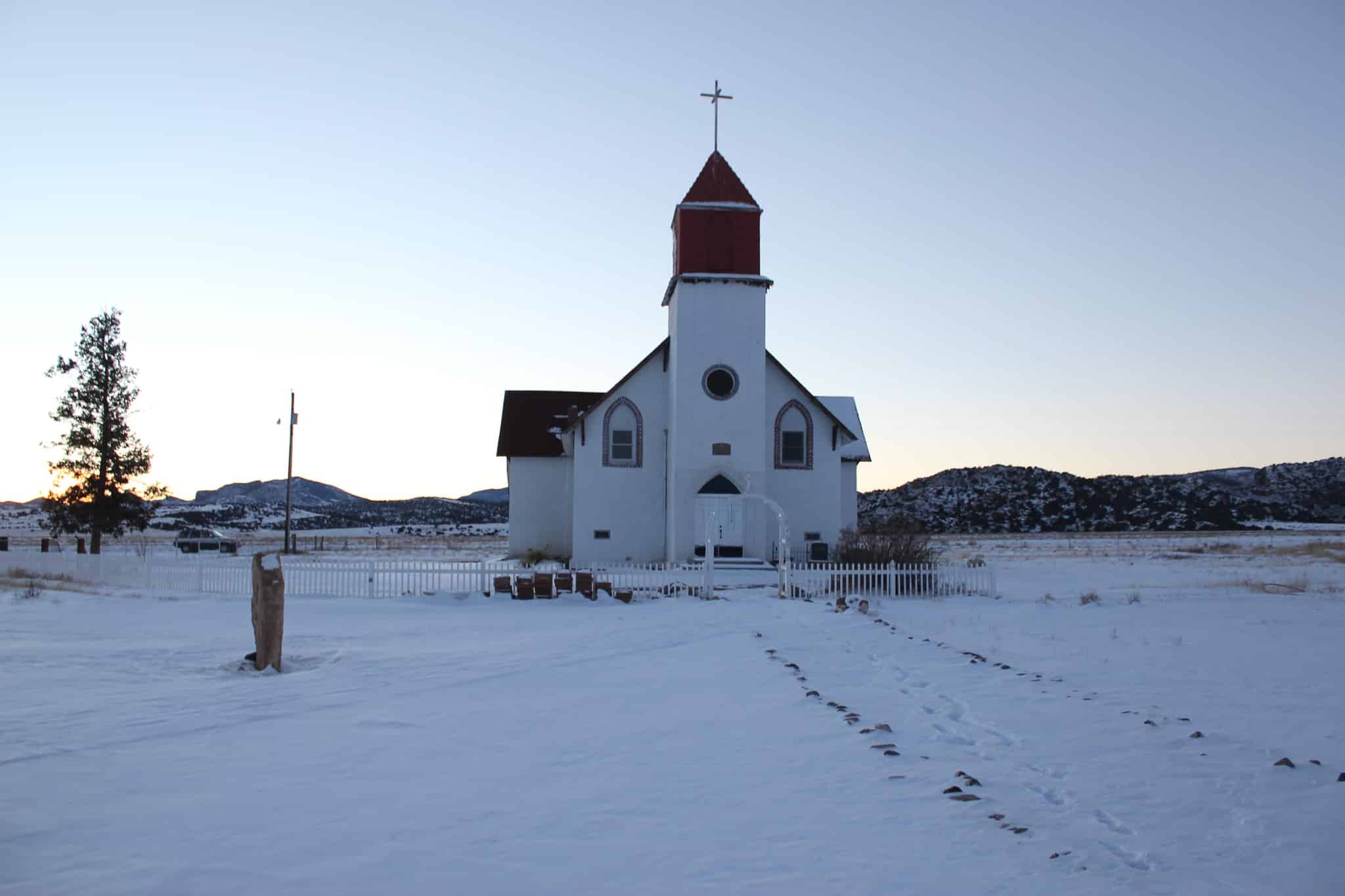 Snow on the ground surrounding a white church