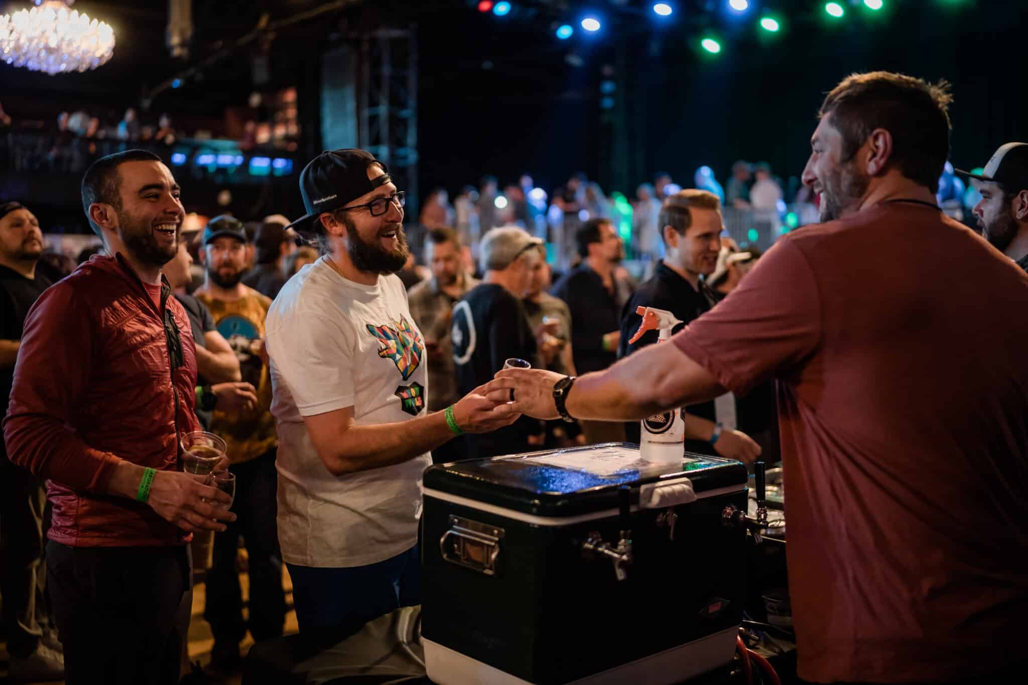 People at a DJ booth shaking hands at a festival