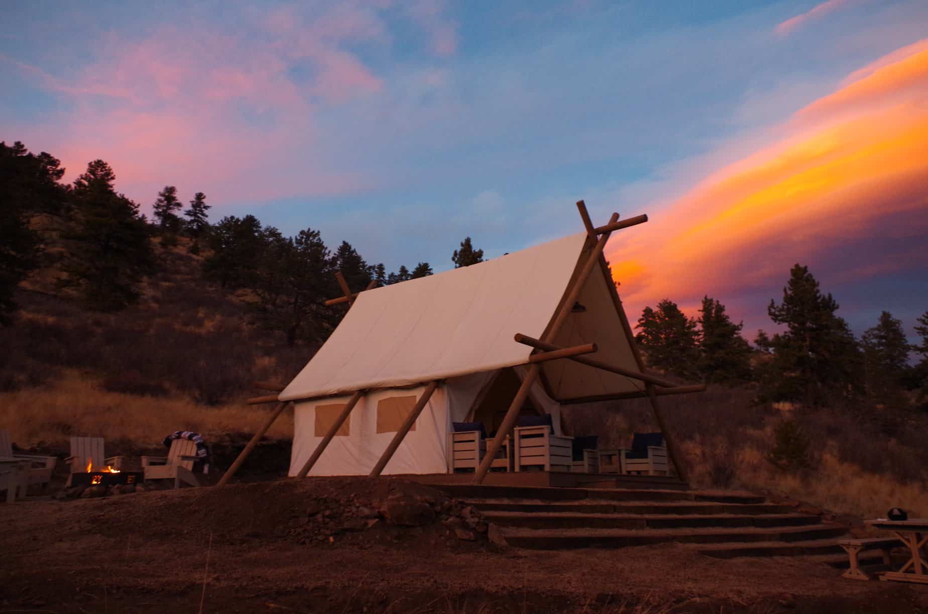 Canvas tent on wooden platform at sunset