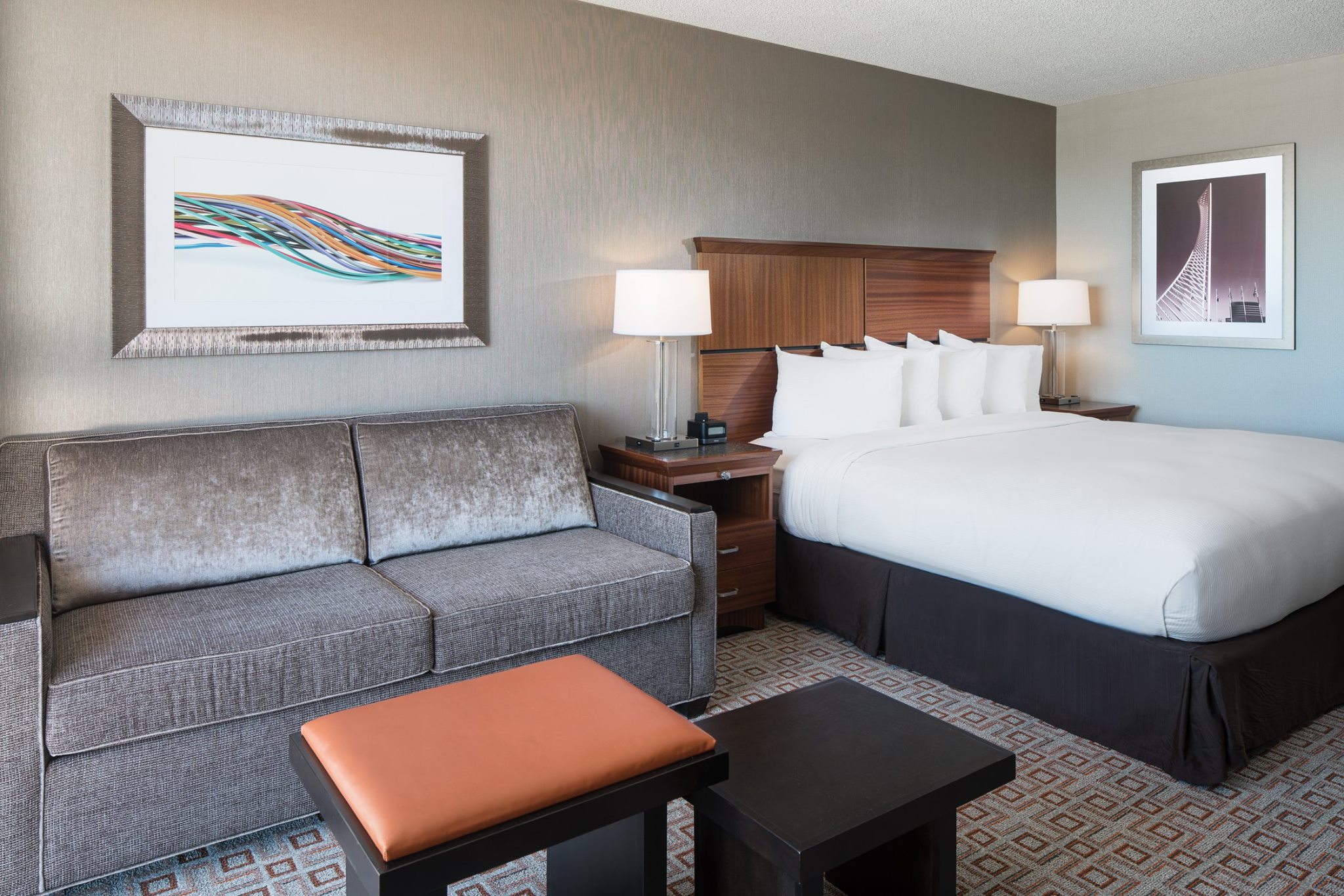 Hotel room with a large king bed and grey sofa