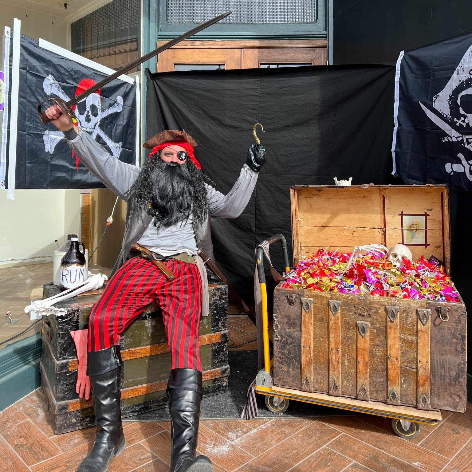 Trick or treat station. Person dressed up as a pirate with a large treasure chest full of candy