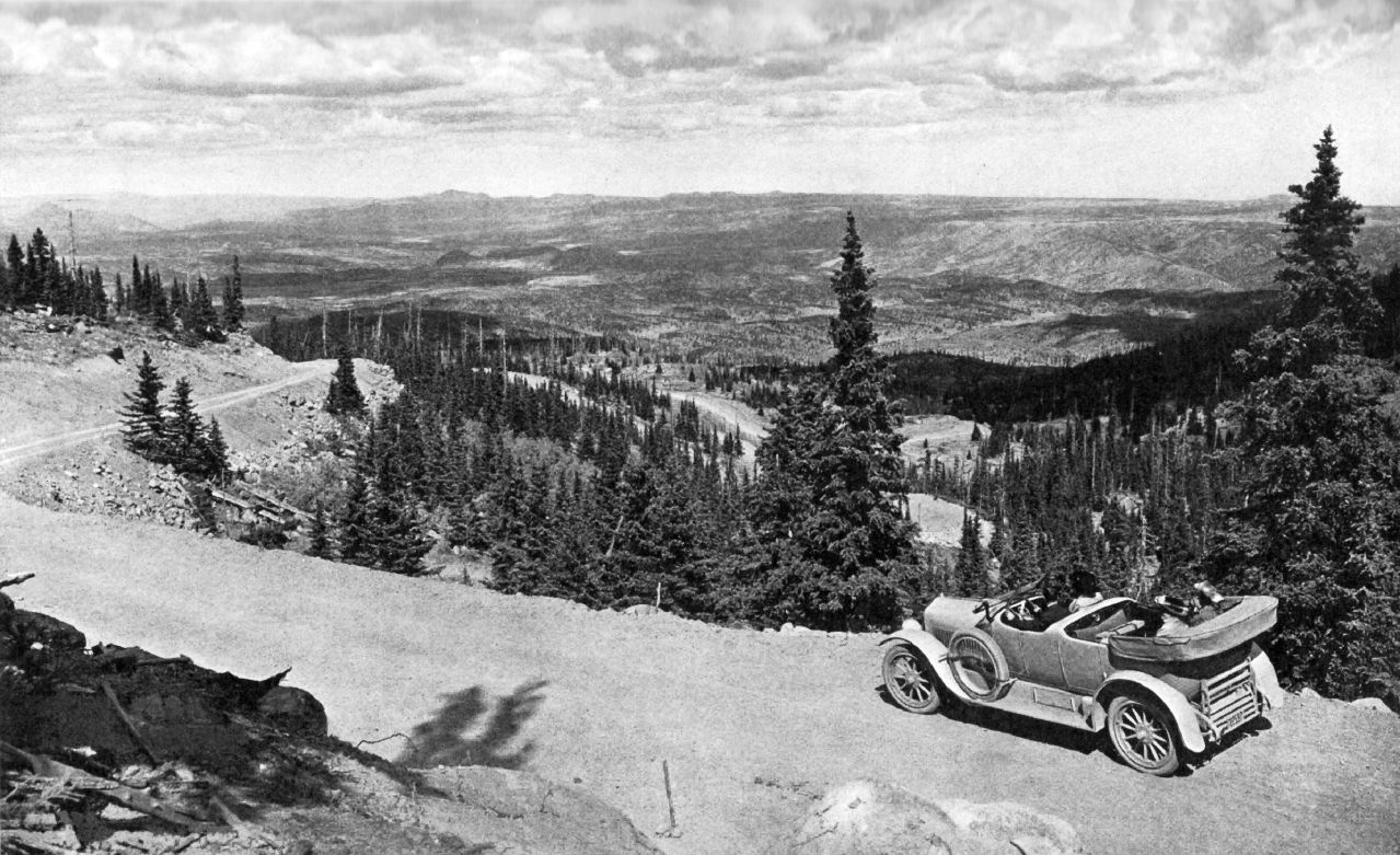 Black and white picture of car driving down mountain road