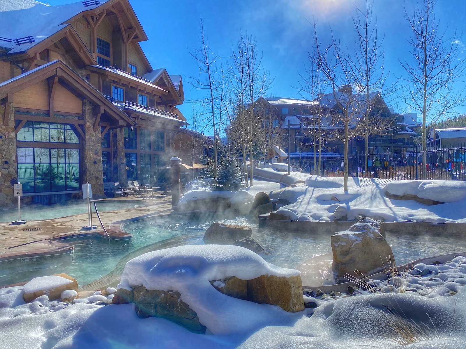 Outdoor hot tub with steam rising surrounded by snow at the Grand Lodge on Peak 7 in Breckenridge, Colorado