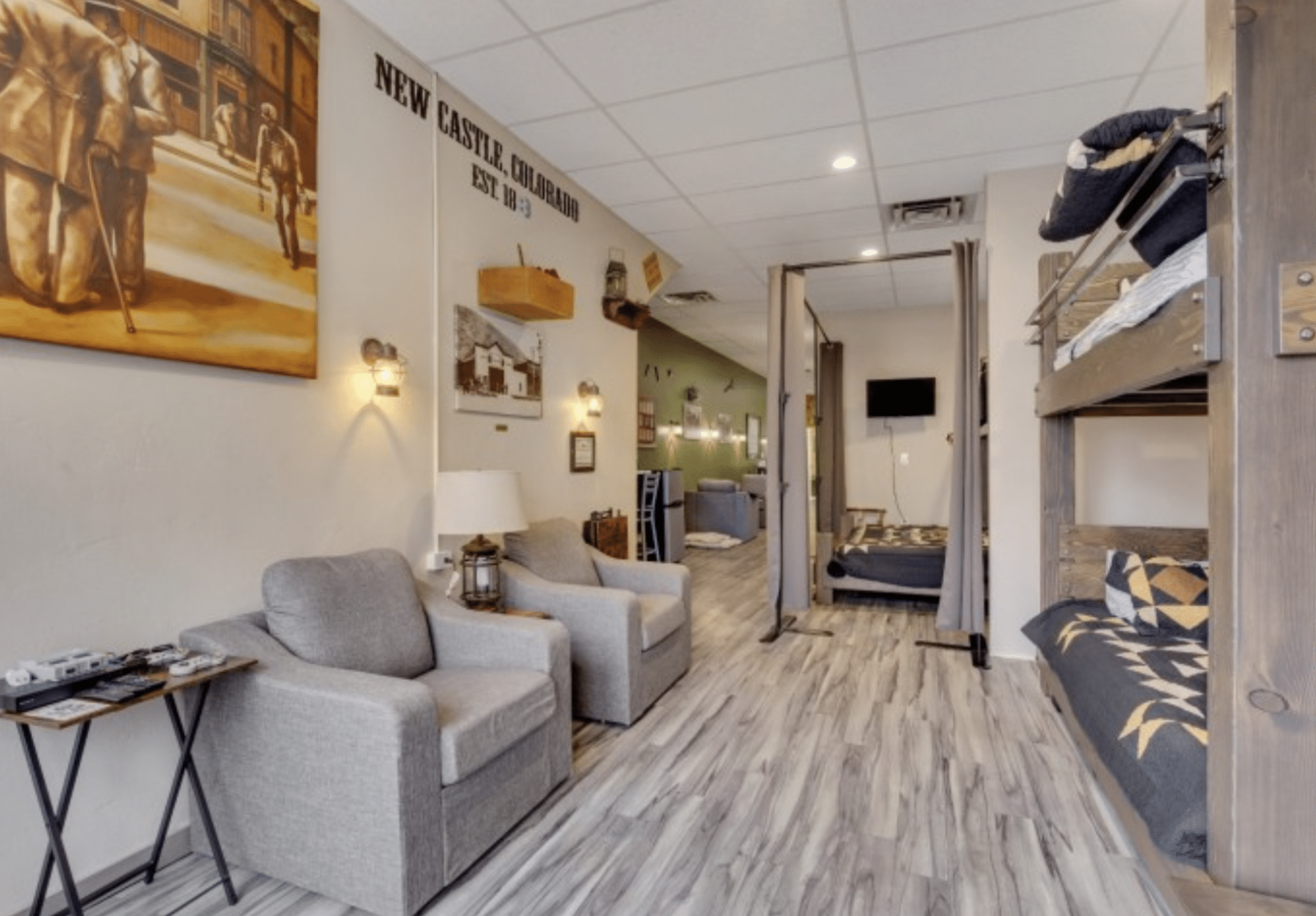 Hotel room with two sitting chairs on the left and bunk beds built into the wall on the right at the Ore House Inn