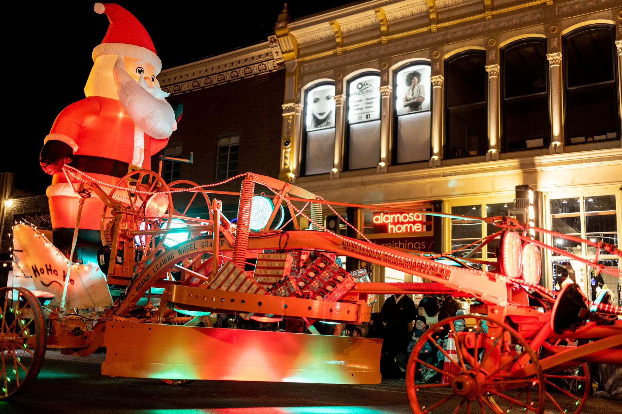 Lit-up car with giant blow up Santa in the bed during the Celebration of Lights parade in Alamosa