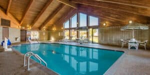 Indoor swimming pool with vaulted wooden ceiling at AmericInn by Wyndham Windsor Ft. Collins