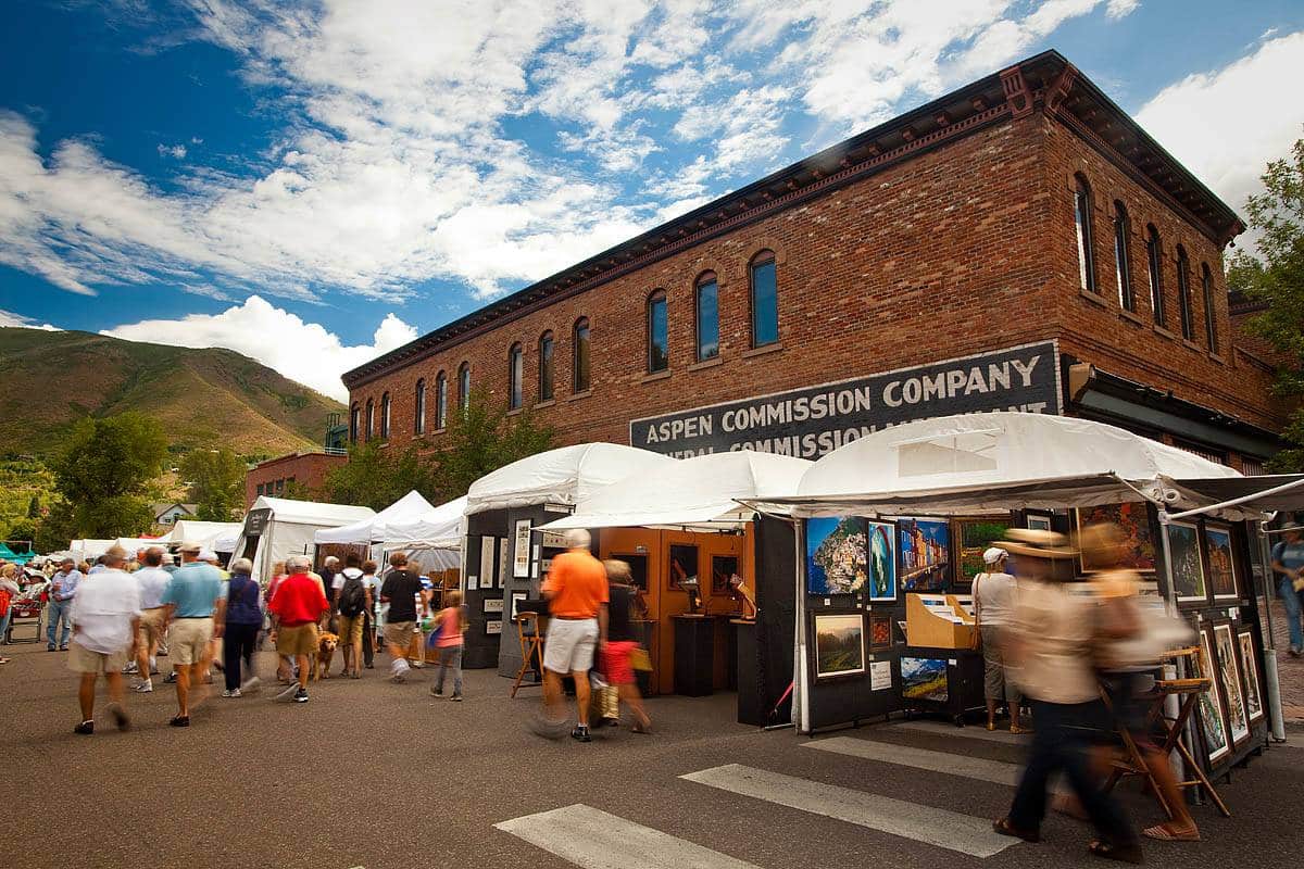 White tents with art vendors and displays on a town street