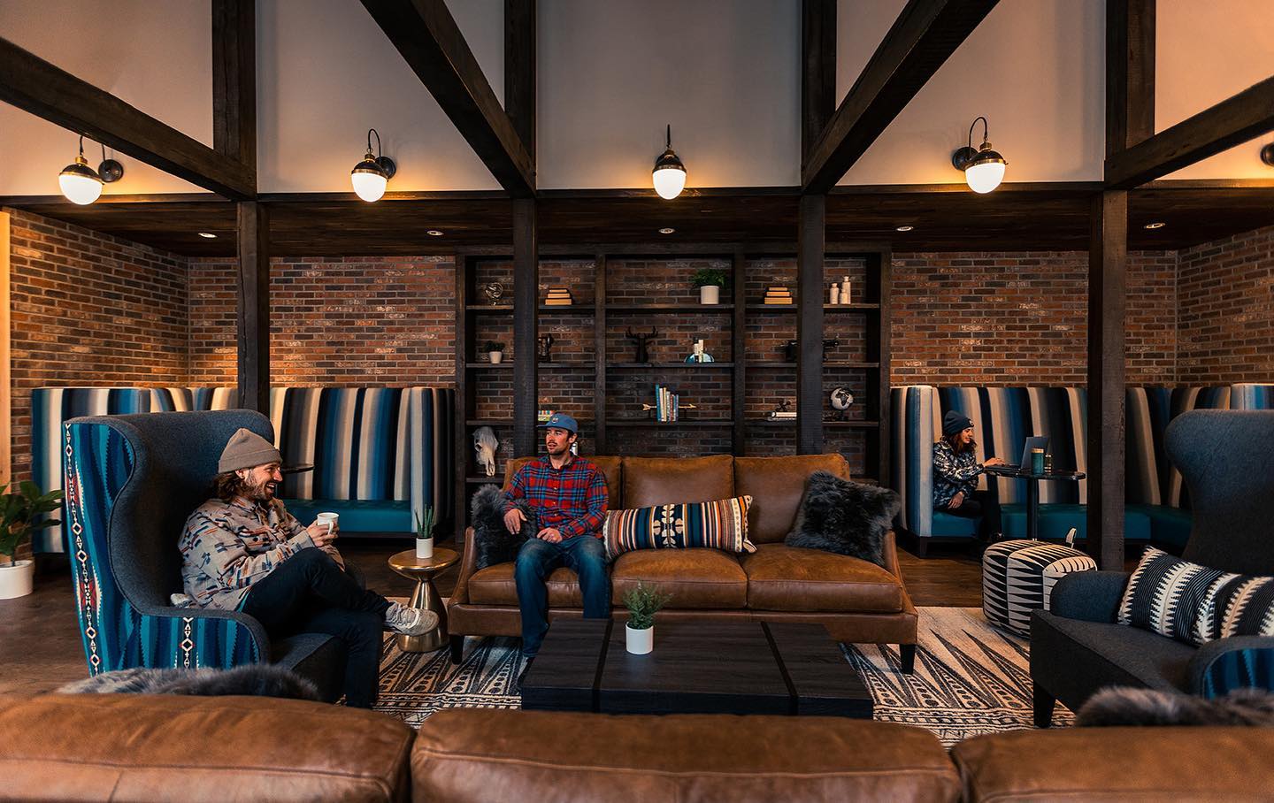 Two people sitting in leather armchairs in a living room of the hostel