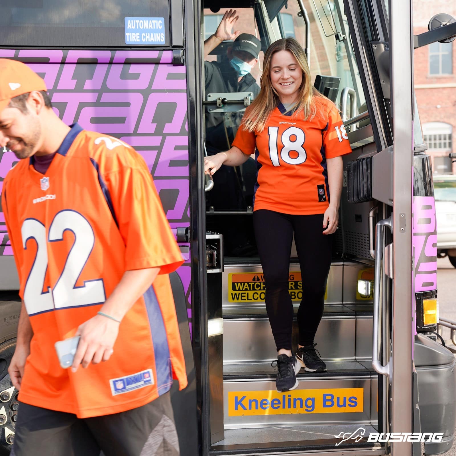 a woman and a male Denver Bronco fans depart the Bustang bus in Colorado