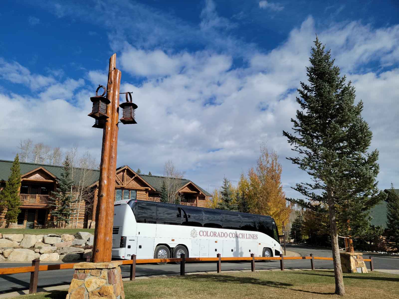 A Colorado Coach Lines bus parked in front of a giant lodge