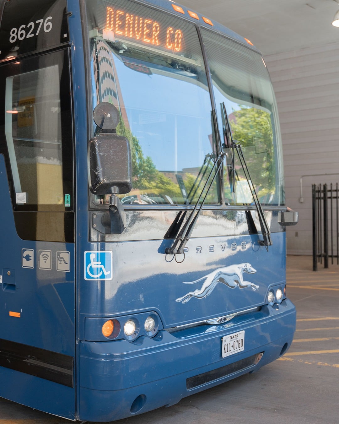 Blueish grey Greyhound charter bus with destination ticker reading Denver, CO