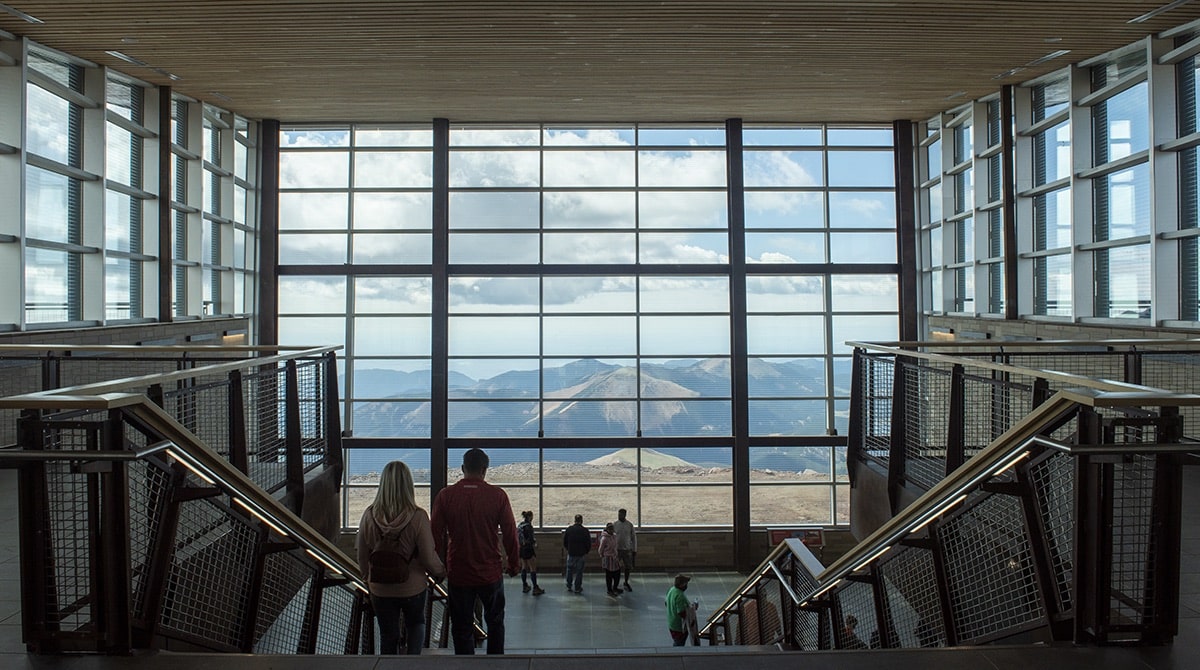 View of the Rocky Mountains outside a huge glass window in the Pikes Peak Summit Visitor Center