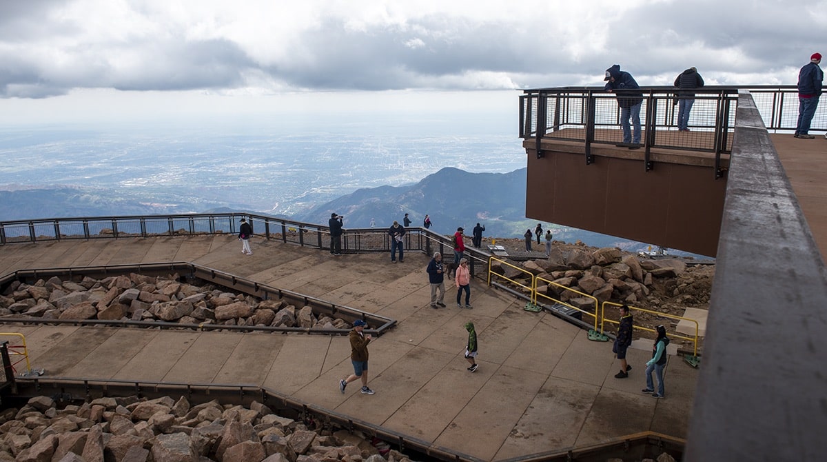 People stand on the outdoor viewing platform at Pike Peak Summit Visitor Center