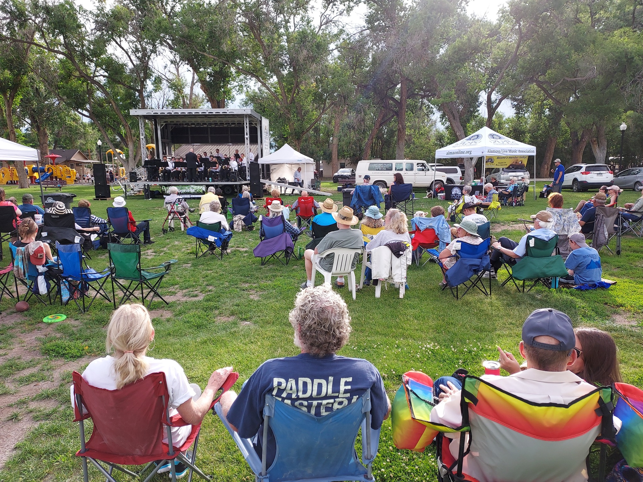 Lawn full of people watching a Sundays at Six music performance in Alamosa.