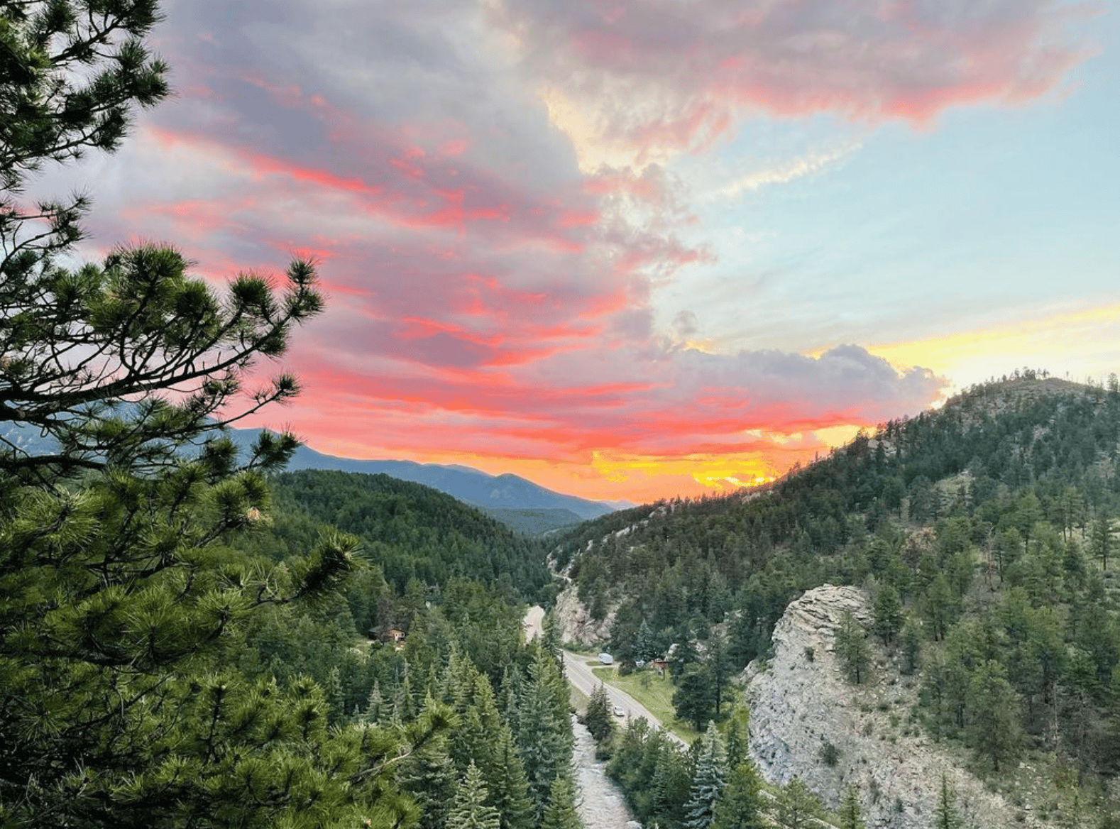 Sunset over green lush mountains with river flowing in the middle at Glen Isle Resort