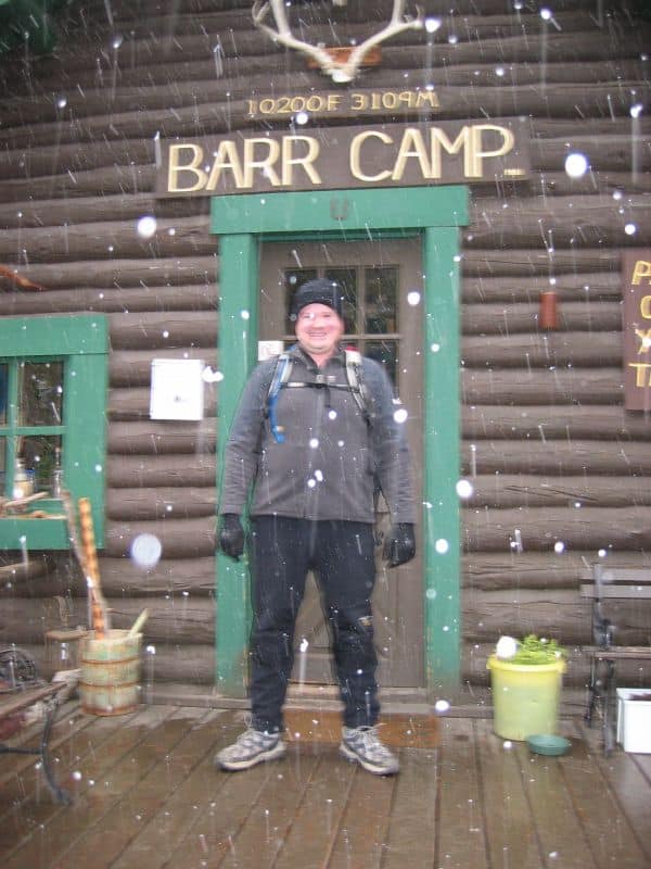 Person standing on the porch with snow falling at Barr Camp, 10,200 feet on Pikes Peak, Memorial Day